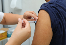 Profissional de saúde aplica vacina contra influenza em paciente em unidade de saúde de Cuiabá