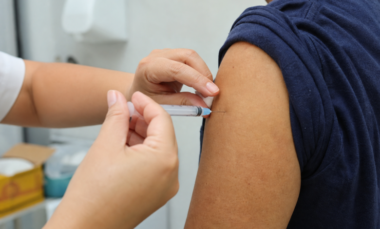 Profissional de saúde aplica vacina contra influenza em paciente em unidade de saúde de Cuiabá