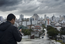 Pessoa usando celular para consultar informações meteorológicas e serviços públicos de emergência em Criciúma
