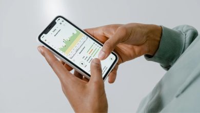 Mãos seguram um celular que exibe um aplicativo de saúde com gráficos e dados.