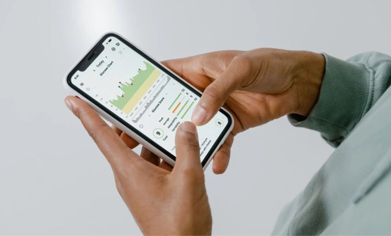 Mãos seguram um celular que exibe um aplicativo de saúde com gráficos e dados.