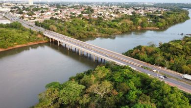 Vista aérea de uma ponte sobre um rio cercado por vegetação em Cuiabá, Mato Grosso.