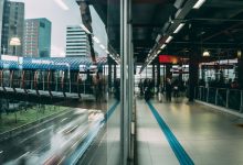 Terminal de transporte urbano moderno com passarela envidraçada e fluxo de passageiros