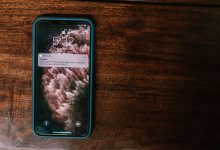Celular exibindo uma mensagem de alerta bancário sobre uma superfície de madeira