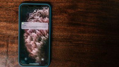 Celular exibindo uma mensagem de alerta bancário sobre uma superfície de madeira