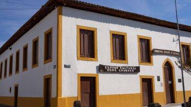 Edifício histórico de arquitetura rústica, com sinalização cultural, sob céu azul.