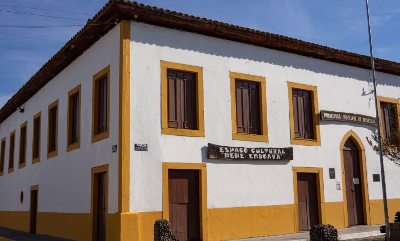 Edifício histórico de arquitetura rústica, com sinalização cultural, sob céu azul.